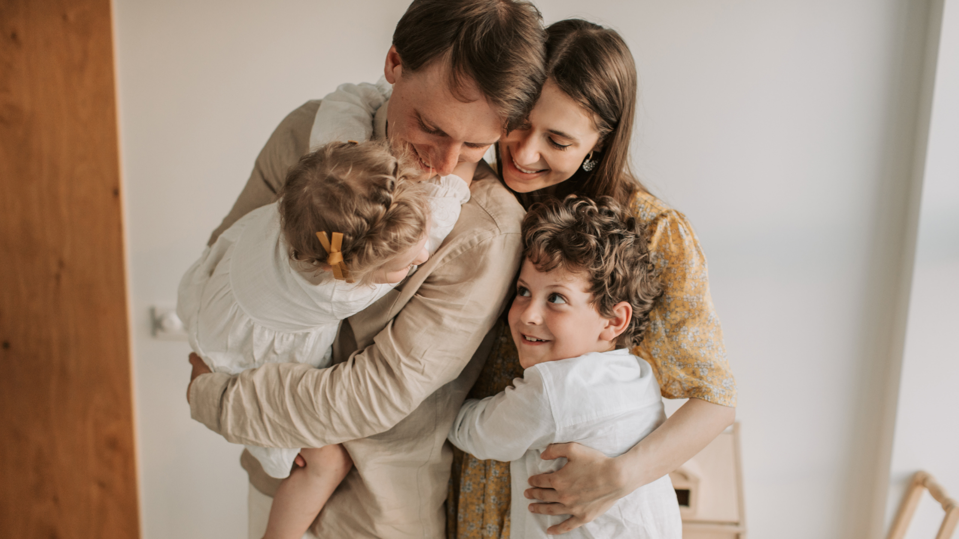 Parents holding their two young children close at home